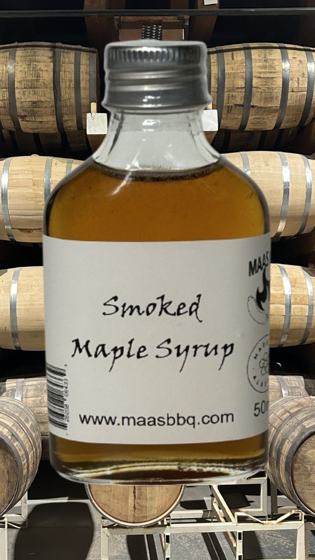 A bottle of Maas BBQ Famous Smoked Maple Syrup made with all-natural ingredients and no additives. A versatile game changer for BBQ meats and a perfect gift for a foodie. Made in Alberta Canada