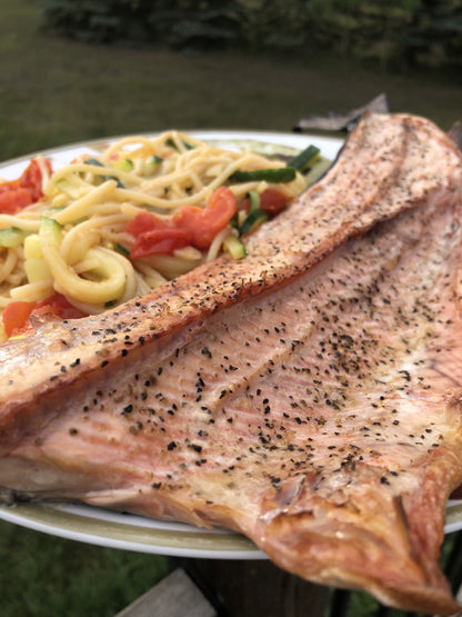 A grilled salmon fillet seasoned with Maas BBQ All Purpose Smoked SPG+ rub, served with a side of vegetable pasta.