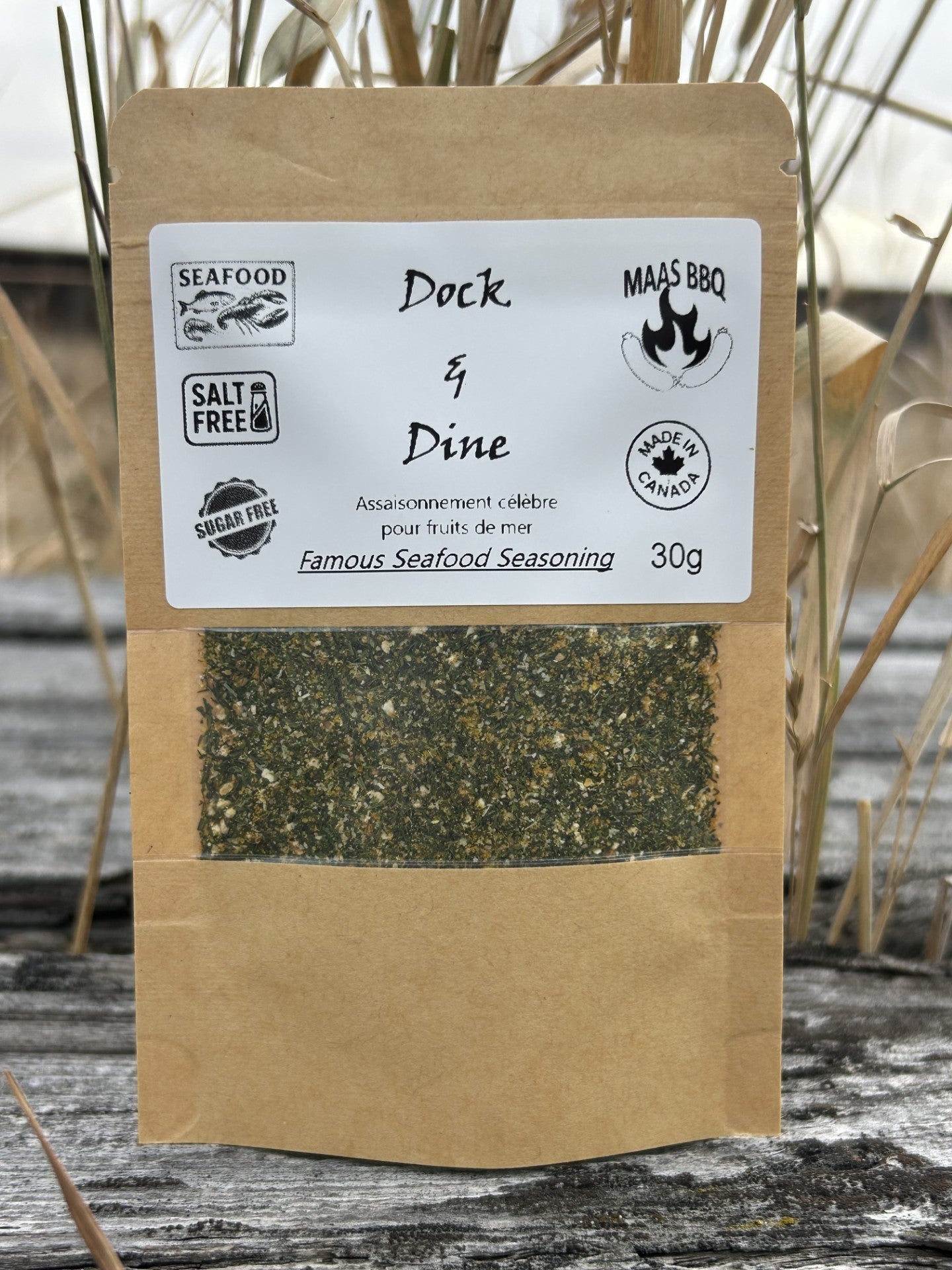 Maas BBQ Dock & Dine unique, all‑natural, no‑salt & no‑sugar Famous Seafood Seasoning spice blend (foodie favorite), labeled “Famous Seafood Seasoning” with “SEAFOOD”, “SALT FREE”, “SUGAR FREE”, and “MADE IN CANADA” 