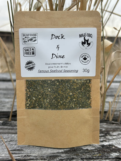 Maas BBQ Dock & Dine unique, all‑natural, no‑salt & no‑sugar Famous Seafood Seasoning spice blend (foodie favorite), labeled “Famous Seafood Seasoning” with “SEAFOOD”, “SALT FREE”, “SUGAR FREE”, and “MADE IN CANADA” 