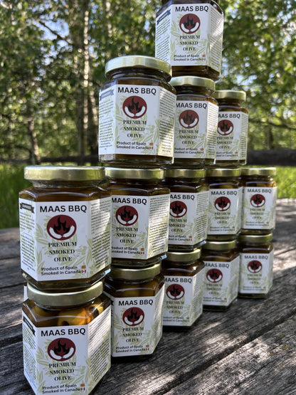 Stack of Maas BBQ Premium Smoked Olive jars, an exclusive gourmet product made in Alberta, Canada, labeled “Canada’s favorite unique smoked spice for BBQ cooking and recipes”, perfect as a great gift for foodies and cooking enthusiasts. Maas BBQ Exclusive Premium Smoked Olives – Canada’s Favorite Gourmet BBQ Ingredient, Unique Smoked Spice Gift for Foodies & Cooking Enthusiasts, Made in Alberta, Canada