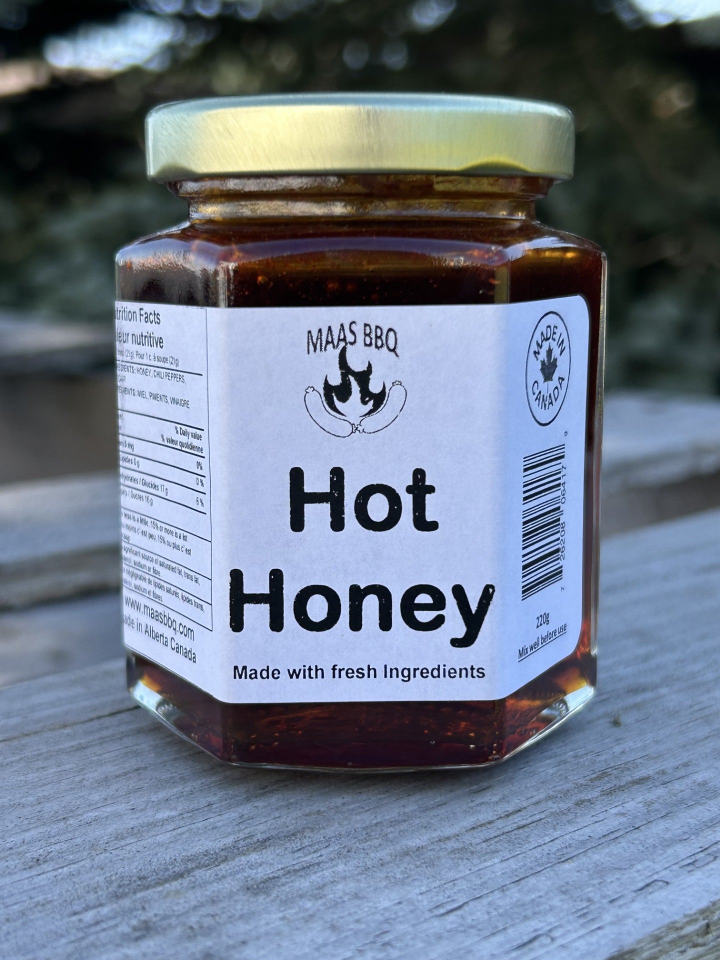 Jar of Maas BBQ hot honey, a unique travel‑size seasoning pack made with fresh ingredients in Alberta, Canada, perfect as a foodie gift for chefs and cooking lovers, labeled “Hot Honey – Made with fresh Ingredients” with Maas BBQ branding.