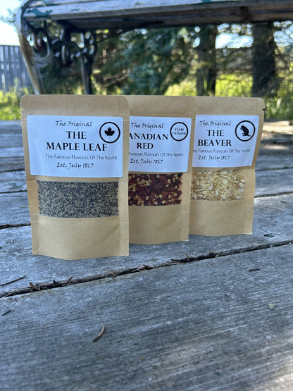Three brown kraft bags of Maas BBQ seasoning blends made in Alberta Canada – “The Maple Leaf”, “Canadian Red”, and “The Beaver” – a unique True North foodie gift pack for cooking, BBQ recipes, and great culinary gifts.