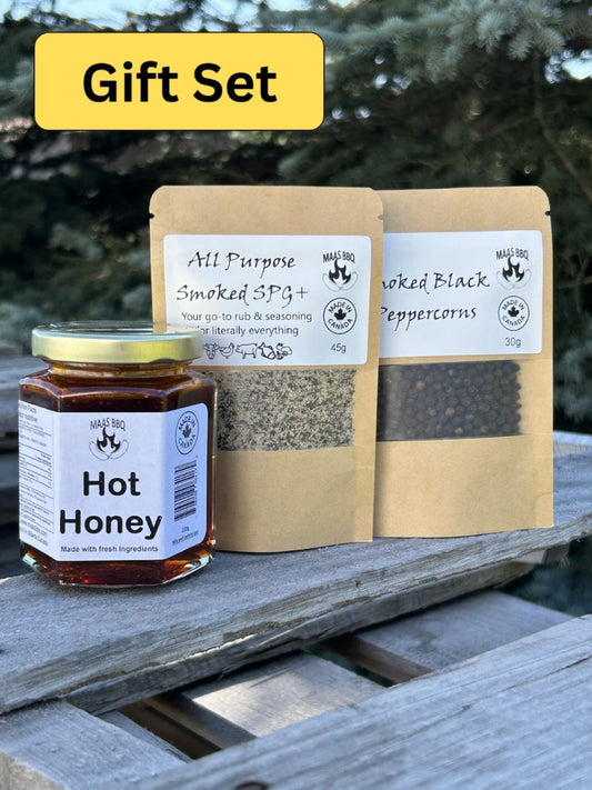 Maas BBQ gourmet combo set featuring a jar of fresh Hot Honey, a 45g bag of All Purpose Smoked SPG+ rub & seasoning, and a 30g bag of Smoked Black Peppercorns in foodie‑size packaging – a unique outdoor foodie gift for chefs, made in Alberta Canada.
