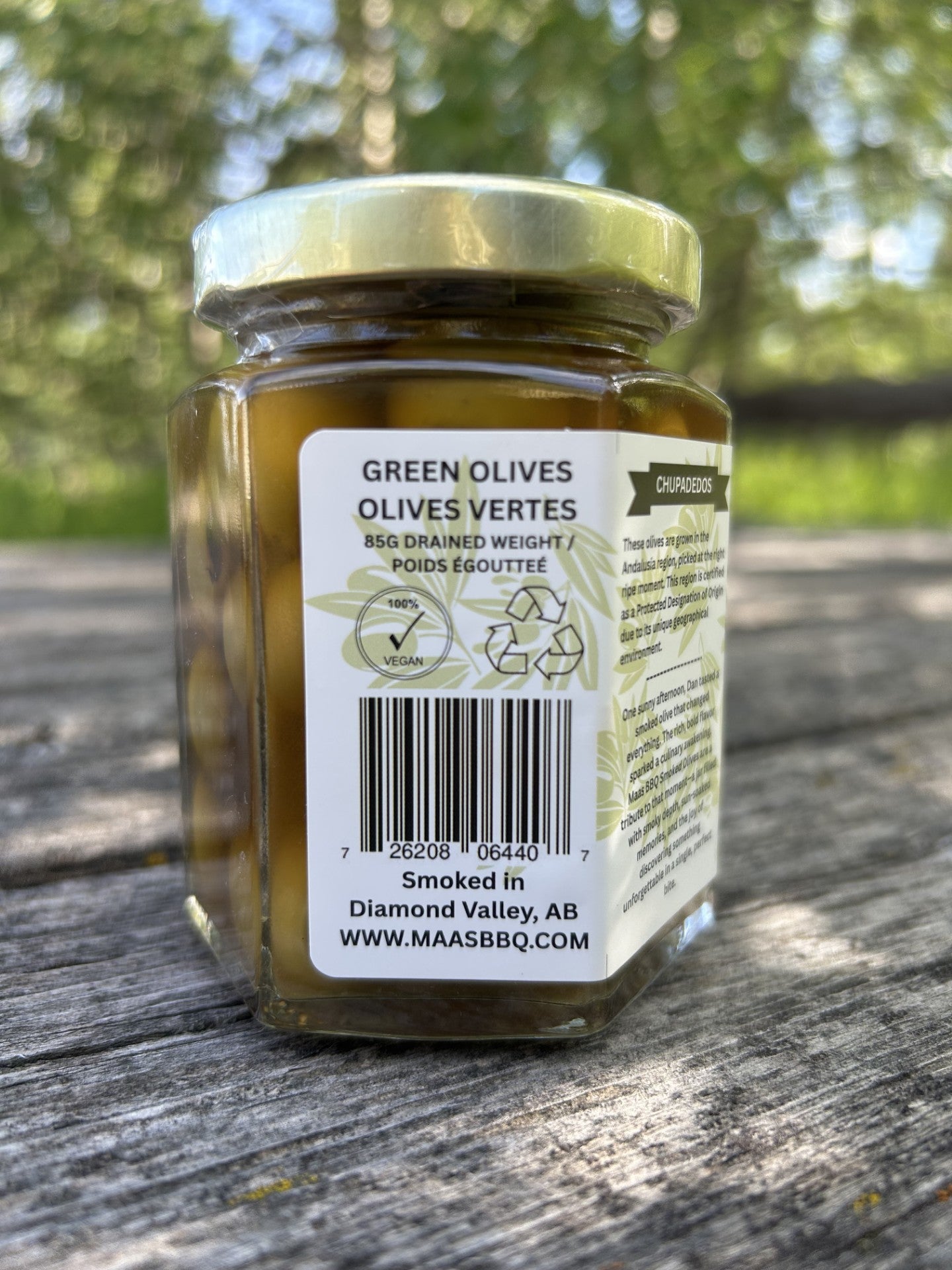 Deluxe jar of Maas BBQ Premium Smoked Gourmet Olives, a unique, Alberta‑Canada made, chef‑grade, foodie favorite BBQ smoked olive oil with smoked spices; perfect gourmet cooking ingredient, for in cocktails, recipe inspiration, and great executive gift, celebrated as Canada’s favorite premium smoked olive delicacy.