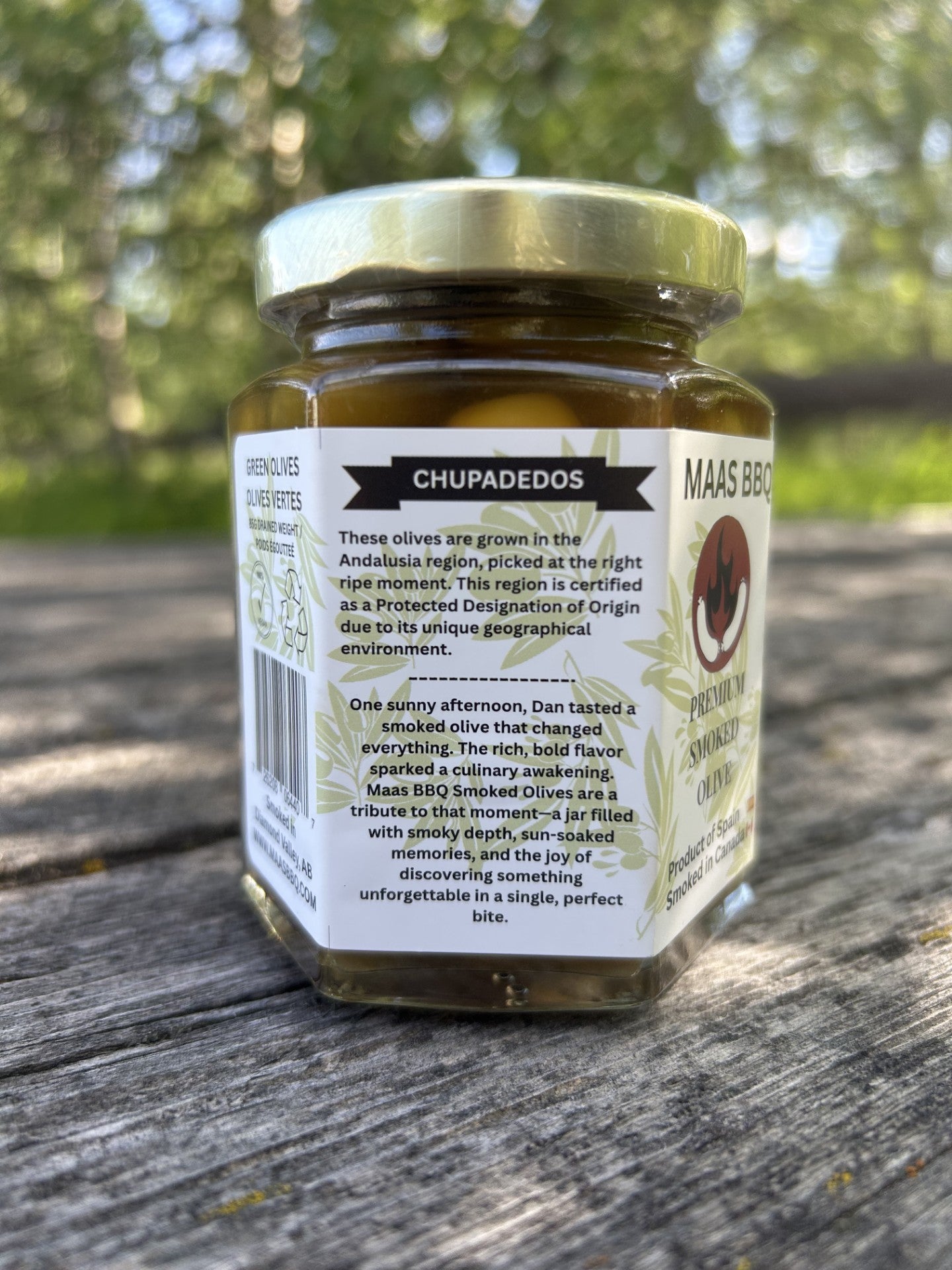 Deluxe jar of Maas BBQ Premium Smoked Gourmet Olives, a unique, Alberta‑Canada made, chef‑grade, foodie favorite BBQ smoked olive oil with smoked spices; perfect gourmet cooking ingredient, recipe inspiration, and great executive gift, celebrated as Canada’s favorite premium smoked olive delicacy.