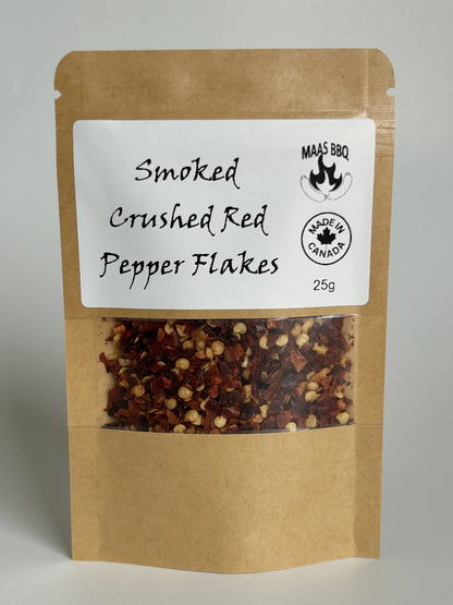 A 25g kraft pouch of Maas BBQ Smoked Crushed Red Pepper Flakes, showcasing the vibrant red flakes. This premium, unique smoked spice is made in Alberta, Canada, perfect for adding gourmet flavor to cooking, BBQ, and recipes for any foodie, and makes a great gift.