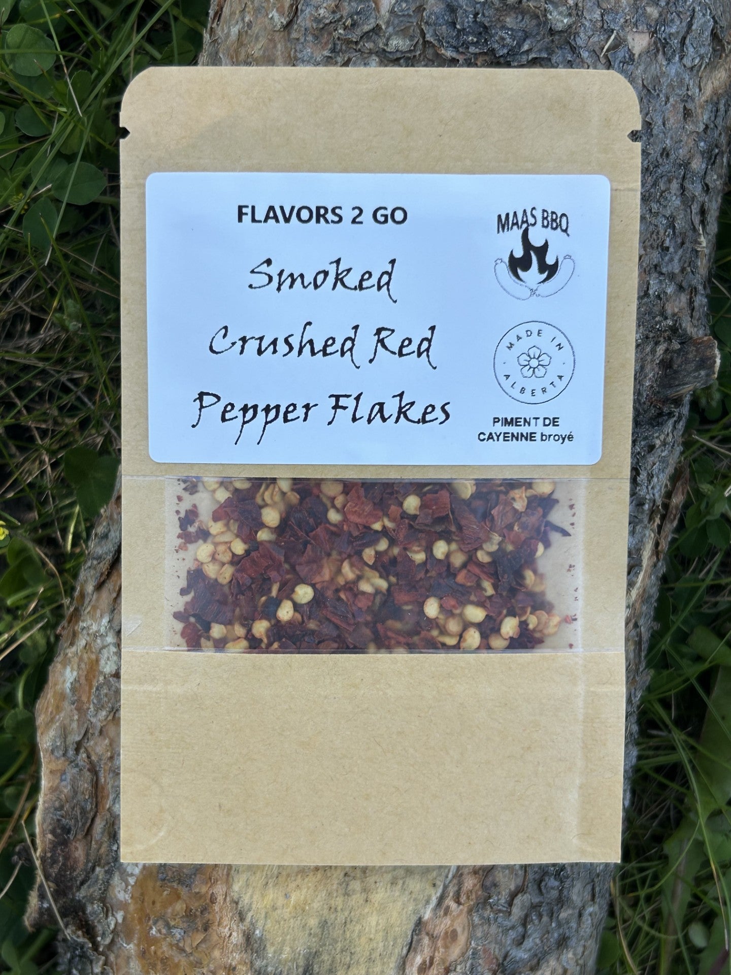 Maas BBQ Smoked Crushed Red Pepper Flakes – Unique Travel‑Size Seasoning Pack for Camping Foodie Adventures, Perfect Gift for Chefs & BBQ Cooking Enthusiasts. Brown kraft packaging of Maas BBQ 'Smoked Crushed Red Pepper Flakes' travel‑size seasoning pack labeled 'Flavors 2 Go, Made in Alberta,' featuring a transparent window of unique smoked red pepper flakes, ideal for camping foodie cooking, chef gifts, and BBQ seasoning on adventures.