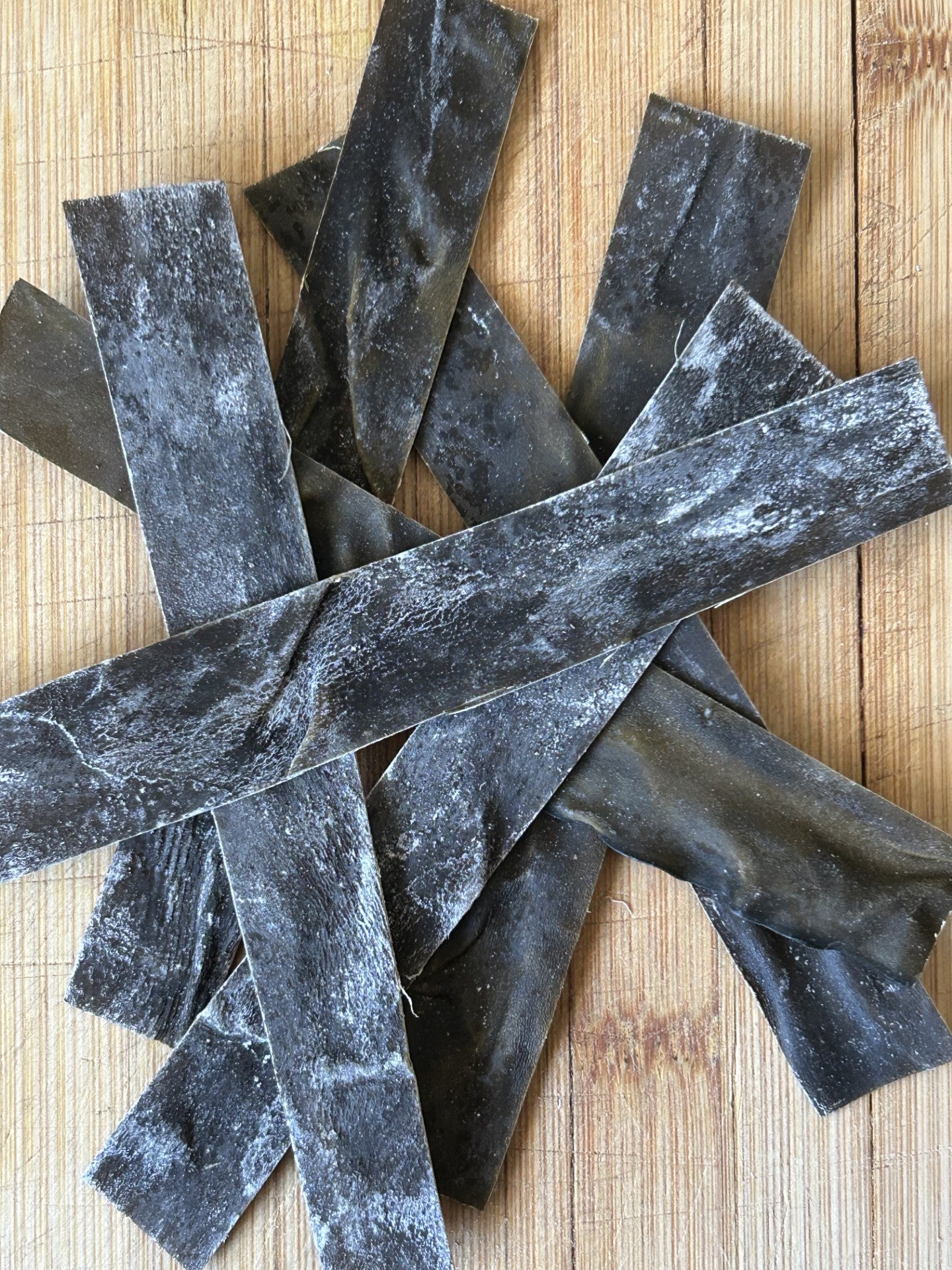 A close-up of black, smoked kelp jerky strips arranged in a star pattern on a wooden cutting board, dusted with white seasoning; perfect for a Maas BBQ vegan, plant‑based, gourmet chef recipe as a flavorful snack or BBQ topping.
Culinary tags: #MaasBBQ #vegan #chef #gourmet #plantbased #smokedkelp #jerky #BBQ #culinary #snack #seaweed #foodie #sustainable #farmfresh #diyfood 