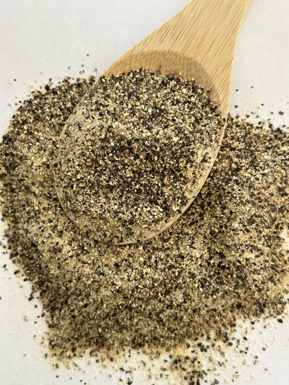 Maas BBQ Smoked SPG seasoning blend, a unique Alberta Canada‑made chef spice mix for BBQ, grilling, and cooking – perfect foodie gift shown on a wooden spoon with coarse pepper and salt grains, ideal for seasoning meats, vegetables, and rubs in gourmet cooking.