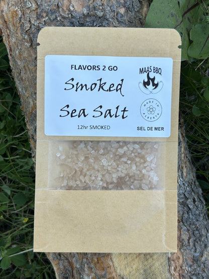 Maas BBQ Smoked Sea Salt – Unique Travel‑Size Seasoning Pack for Camping Foodie Adventures | Chef‑Approved Gift for Cooking Enthusiasts. Brown kraft packaging of Maas BBQ Flavors 2 Go smoked sea salt, a unique travel‑size seasoning pack labeled '12hr SMOKED Sea Salt – Sel de Mer, Made in Alberta,' ideal for camping foodie cooking and chef gift ideas.