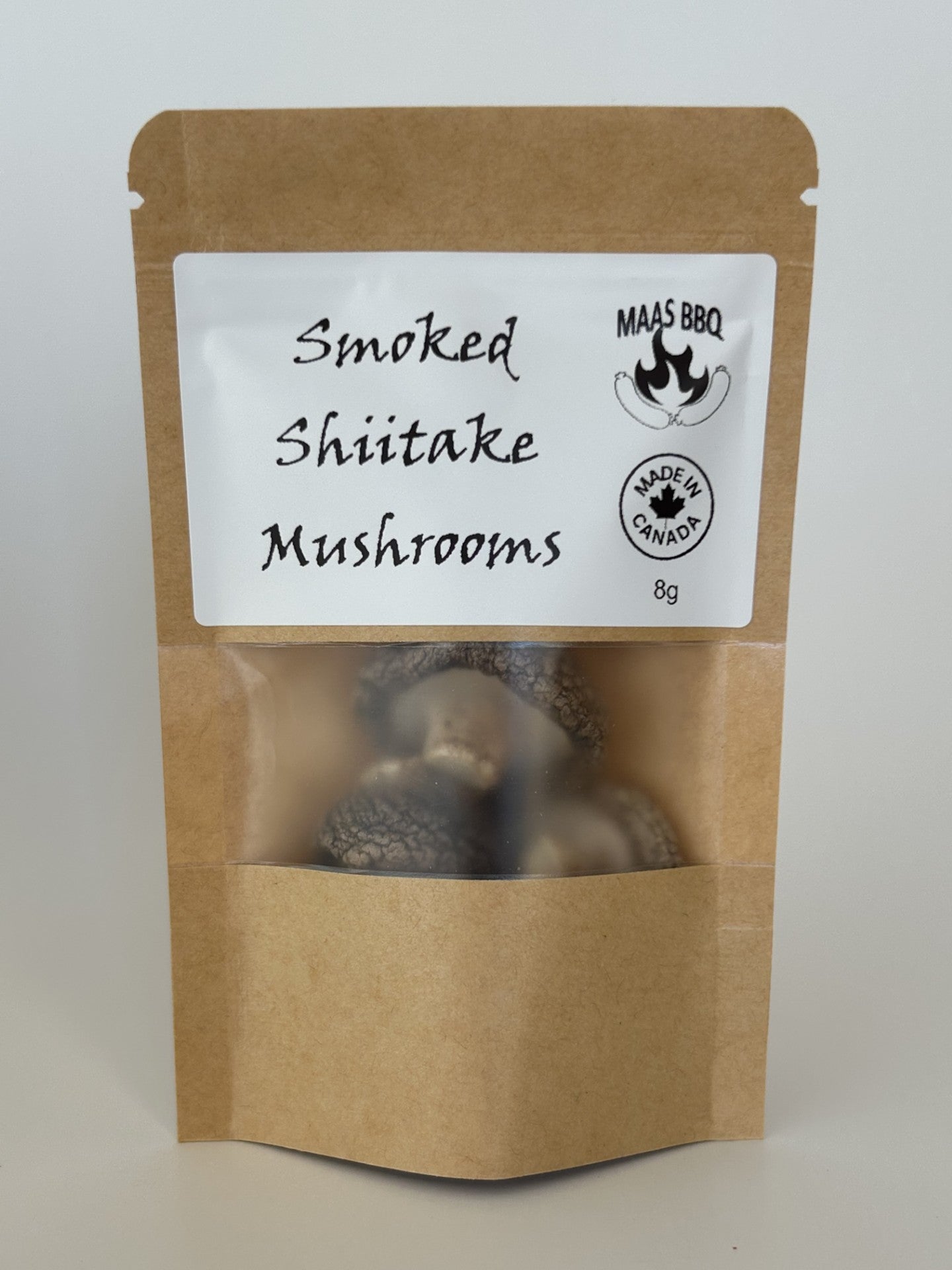 An 8g kraft pouch of Maas BBQ Smoked Shiitake Mushrooms, featuring the "Made in Canada" logo. These high‑end, unique gourmet smoked shiitake mushrooms, crafted in Alberta, Canada, are perfect for chefs and foodies to infuse dishes with rich, smoky umami flavors, and make an excellent gift for culinary enthusiasts. Maas BBQ Smoked Shiitake Mushrooms (8g) – Unique Gourmet Flavor from Alberta, Canada | High‑End Ingredient for Chefs, Foodies & Unique Gifts