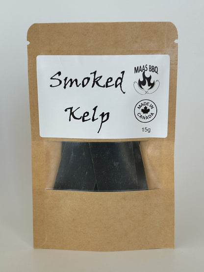 A brown kraft pouch with a white label reading “Smoked Kelp” and “MAAS BBQ” with a flame logo, plus a “Made in Canada” stamp and 15g weight; the pouch contains black smoked kelp strips, a vegan gourmet chef product. Vegan, Plant Based
Culinary tags: #SmokedKelp #MaasBBQ #Vegan #Chef #Gourmet #CanadianFood #BBQ #Seaweed #PlantBased #Snack