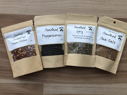 Smoked Red Pepper, Peppercorns, SPG, Smoked Sea Salt in brown paper travel size pouches.