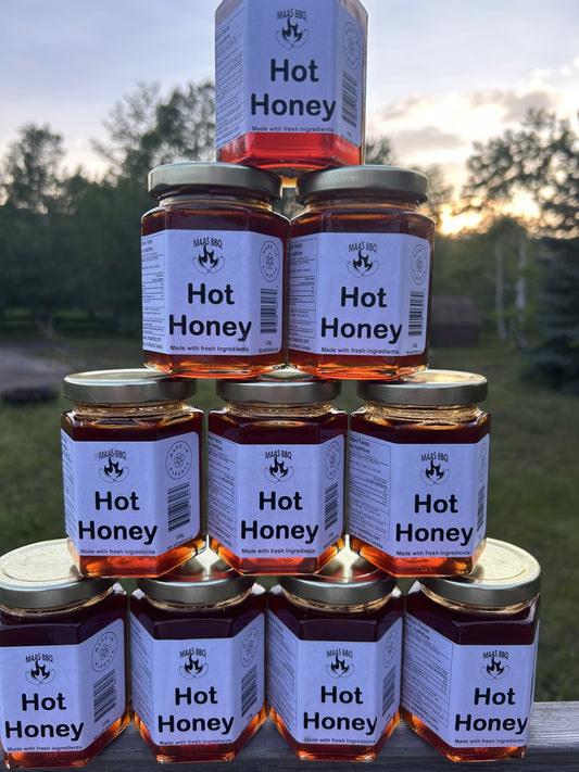 A pyramid of Maas BBQ Hot Honey jars made with fresh, natural ingredients and no additives. A versatile condiment and perfect gift for a foodie.